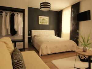 a bedroom with a white bed and a black wall at Guest House Klaudija in Trogir