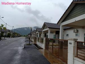 uma fila de casas ao lado de uma rua em Madiena Homestay em Kampung Gurun