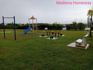 um parque com um parque infantil com escorregas e baloiços em Madiena Homestay em Kampung Gurun