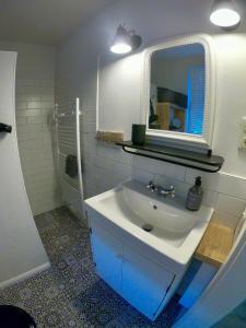 W łazience znajduje się biała umywalka i lustro. w obiekcie Hafen Liebe w mieście Neustadt in Holstein