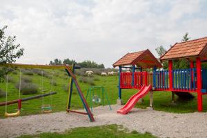 a playground with a slide and swings at Lavanda farm apartmani in Rakovica