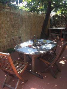 una mesa de picnic con 2 sillas y una botella de vino en Casa Lia, en Arcola