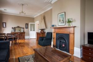 - un salon avec une cheminée et une table dans l'établissement Grand Old Duke, à Hobart