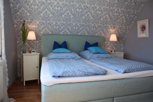 a bedroom with two beds with blue pillows at Ferienwohnung-Sonnenblume in Grube