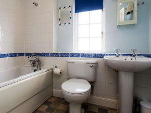 a bathroom with a toilet and a sink and a tub at 1 Bell Lodge, Thorpeness in Thorpeness