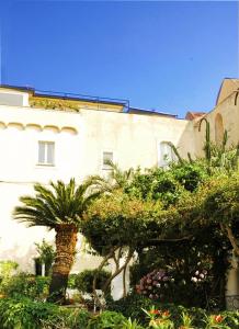 un bâtiment avec des arbres et des plantes devant lui dans l'établissement B&B MilleQuattrocento, à Gaète