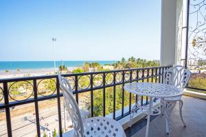 balcón con mesa y sillas y la playa en Art De Sea Hua Hin, en Hua Hin