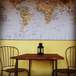 a table with two chairs and a world map on the wall at B&B MilleQuattrocento in Gaeta