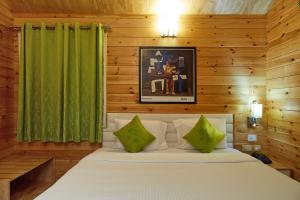 a bedroom with a bed with a green curtain at Bodhiwoods Resorts in Mahabalipuram