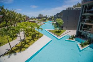 een luchtzicht op een zwembad van het resort met palmbomen bij La Vela Khao Lak - SHA Extra Plus in Khao Lak