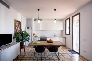 a kitchen with a wooden table and black chairs at City Center Apartments in Tarragona