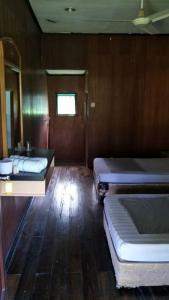 
a small room with a bed and a desk at Benarat Lodge in Mulu
