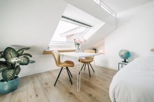 - une chambre avec un lit, une table blanche et des chaises dans l'établissement Zylt Zandvoort, à Zandvoort