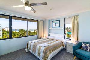een slaapkamer met een bed en een groot raam bij Burgess @ Kings Beach Apartments in Caloundra