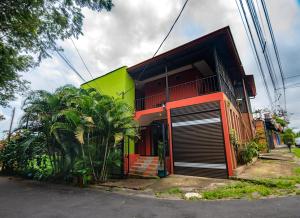 une maison colorée avec une porte de garage devant elle dans l'établissement Melrost Airport Bed & Breakfast, à Alajuela