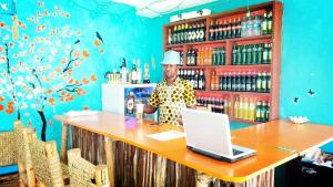 a man standing at a counter with a laptop at Diani Hostel in Diani Beach