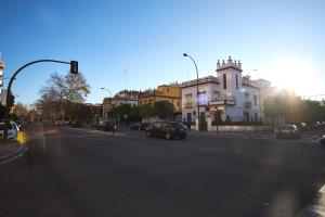 uma rua com carros a descer uma rua com um edifício em Nervion Paradise em Sevilha