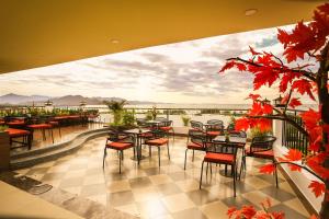 a restaurant with tables and chairs on a balcony at Hacom Galaxy Hotel in Phan Rang–Tháp Chàm