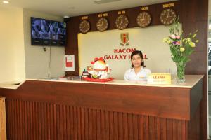 a woman sitting at a counter in a restaurant at Hacom Galaxy Hotel in Phan Rang–Tháp Chàm