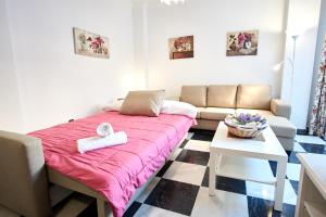 um pequeno quarto com uma cama e um sofá em Nervion Paradise em Sevilha