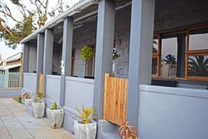 a building with potted plants sitting outside of it at FlowerBox Cottages in Mossel Bay