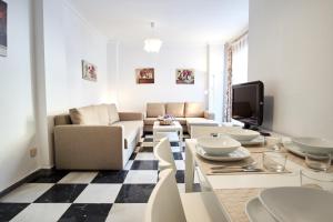 uma sala de estar com um sofá e uma mesa em Nervion Paradise em Sevilha