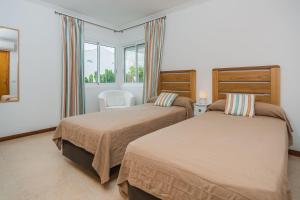 a bedroom with two beds and a window at Villa Maria in El Port +16 photos