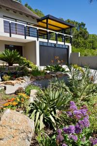 ein Garten vor einem Haus mit Blumen in der Unterkunft Normarie's Guesthouse in Wilderness
