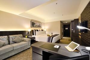 um quarto de hotel com uma cama e um sofá em Guide Hotel Kaohsiung Liuhe em Kaohsiung