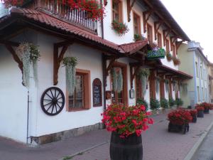 a building with flowers on the side of a street at Penzion Restaurace u Helferů in Libuň