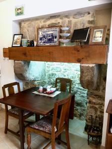 a dining room with a table and a stone fireplace at Ker Viviane in Dinan