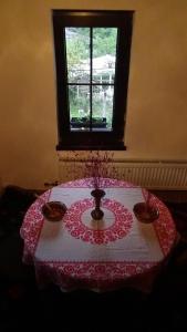 奧沙克的住宿－Бутикова къща "МЕРИ"，一张桌子,上面有红白桌布和一个窗口
