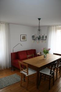 sala de estar con mesa de madera y sofá rojo en Maison d'Alsace, en Breitenbach-Haut-Rhin