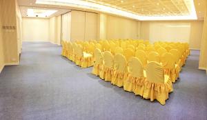 an empty room with yellow chairs in it at Silvermine Beach Resort in Hong Kong