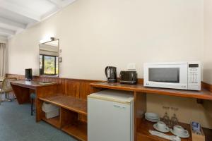 a kitchen with a microwave and a counter top at Village Family Motor Inn in Launceston