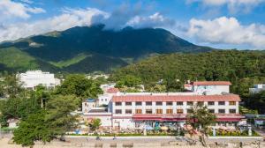 eine Stadt mit einem Berg im Hintergrund in der Unterkunft Silvermine Beach Resort in Hongkong