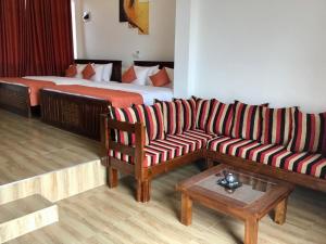 a living room with a couch and a bed at Avonil Resort Yala in Tissamaharama