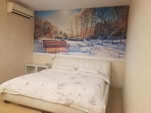 een slaapkamer met een bed met een schilderij aan de muur bij Hotel Tebrau CT in Johor Bahru