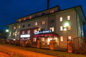 a building with a sign that reads mantis inn honors at Hotel Komes in Skarżysko-Kamienna
