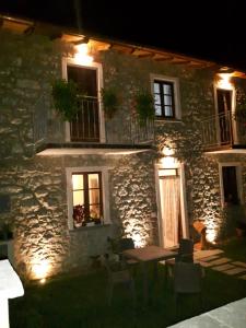 a stone building with a table outside of it at night at B&B da Morena in Gorfigliano