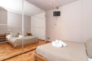 a bedroom with two beds and a mirror at Weflating Diagonal in Barcelona