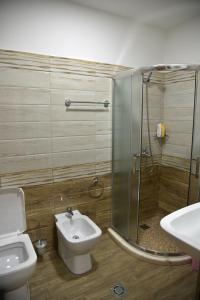 y baño con ducha, aseo y lavamanos. en Alindro City Center Apartment 2 en Tirana