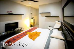 a bedroom with a bed with an orange towel on it at Infinity Guesthouse in Koh Tao
