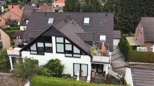ein großes weißes Haus mit schwarzem Dach in der Unterkunft 25 Schützenstraße in Diekholzen
