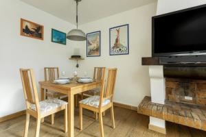 uma sala de jantar com mesa e cadeiras e uma televisão de ecrã plano em Apartment Lyret em Chamonix-Mont-Blanc