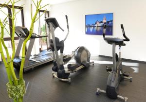 a gym with three exercise bikes in a room at ACHAT Hotel Regensburg im Park in Regensburg