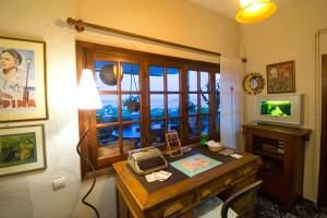 a room with a desk with a telephone and a window at Goddess Artemis Balcony Apartment Near Athens Airport in Artemida