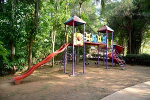 een park met een speeltuin met glijbanen en een diaktop bij Nature Trails Durshet, Khopoli in Khopoli