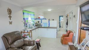 a living room with a couch and two chairs at Suzy's Place in Port Edward