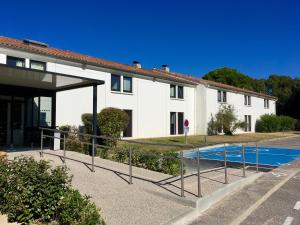 - un bâtiment avec une piscine en face dans l'établissement Hotel du Parc Euromédecine by AKENA, à Montpellier
